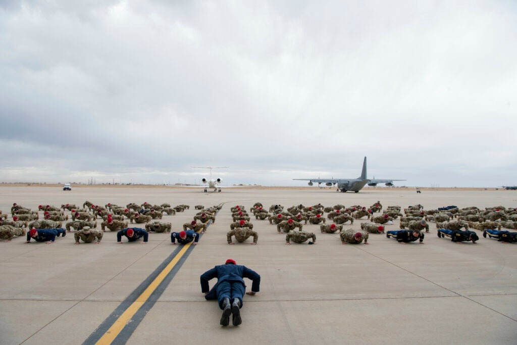 Staff Sgt. Alaxey Germanovich, 26th Special Tactics Squadron combat controller, leads U.S. Air Force and U.S. Army Special Tactics service members as they perform memorial pushups following an Air Force Cross ceremony Dec. 10, 2020, at Cannon Air Force Base, N.M. Barbara Barrett, Secretary of the Air Force, presented the medal to Staff Sgt. Alaxey Germanovich, 26th Special Tactics Squadron combat controller, for his actions during a fierce firefight in Nangarhar Province, Afghanistan, April 8, 2017. Germanovich’s efforts were credited with saving over 150 friendly forces and destroying 11 separate fighting positions. (U.S. Air Force photo by Staff Sgt. Michael Washburn)