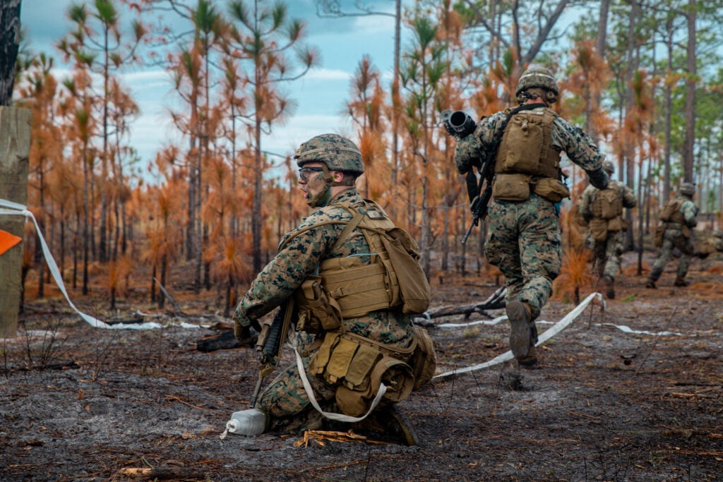 U.S. Marine Corps Lance Cpl. David Keller, a combat engineer with 2nd Combat Engineer Battalion, 2d Marine Division, directs Marines through a cleared lane in a live-fire assault on range Golf-36 (G-36), Camp Lejeune, North Carolina, Dec. 12, 2020. Range G-36 is the newest addition to the Camp Lejeune training environment. This range is designed to accommodate company-size assaults and evolutions. (U.S. Marine Corps photo by Lance Cpl. Jacqueline Parsons)