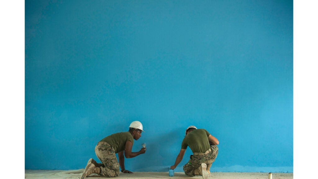 Marine Corps Lance Cpl. Blake Hernandez and Pfc. Brady McVane paint the wall of a school in Chanthaburi, Thailand, Feb. 25, 2020, as part of Exercise Cobra Gold 2020 (Marine Corps photo / Staff Sgt. Jordan Gilbert)