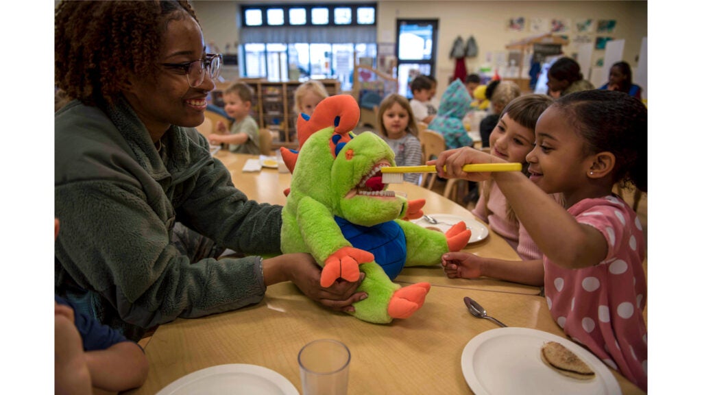 Air Force Senior Airman Bria Lipkins watches a child practice her brushing techniques on a stuffed animal at Holloman Air Force Base, N.M., Feb. 11, 2020. (Air Force photo / Staff Sgt. Christine Groening)