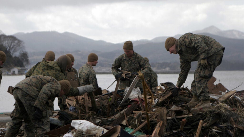 Marines with Battalion Landing Team 2nd Battalion, 5th Marines, 31st Marine Expeditionary Unit, clear debris along the side of a port, April 4. Clearing the debris allowed more access for supplies to get in and made it safer for the locals still living in the area. (Marine Corps photo / Lance Cpl. Garry J. Welch)