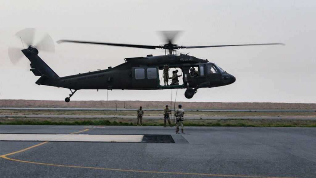 U.S. Army Soldiers hover in a UH-60 Black Hawk helicopter during training at the Udairi Landing Zone, Camp Buehring, Kuwait, Feb. 9, 2019. The crew members, assigned to the 1st Battalion, 108th Aviation Regiment, Kansas Army National Guard, conducted the training to prepare to provide aviation support for an air assault course. Photo was blurred to protect operational security. (U.S. Army National Guard photo by Sgt. Emily Finn)