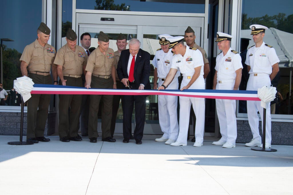 Mr. Arnold Fisher, Honorary Chairman of the Intrepid Fallen Heroes Fund (center), cuts the ceremonial ribbon during the opening of the National Intrepid Center of Excellence (NICoE) Satellite Center aboard Camp Lejeune, N.C., Oct. 02, 2013. The NICoE helps veterans deal with battle-related injuries such as traumatic brain injury and post-traumatic stress. (U.S. Marine Corps photo by Lance Cpl. Andre Dakis, Combat Camera, MCI-East, Camp Lejeune/Released)