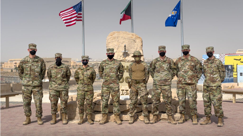 U.S. Airmen from the Wing Innovation Team stand in front of The Rock at Ali Al Salem Air Base, Kuwait, May 13, 2021. These Airmen, in various career fields across the installation, had helping hands in creating a product that automates about 90% of data scrubs units travel representatives are required to do monthly. (U.S. Air Force photo by Senior Airman Taryn Butler)