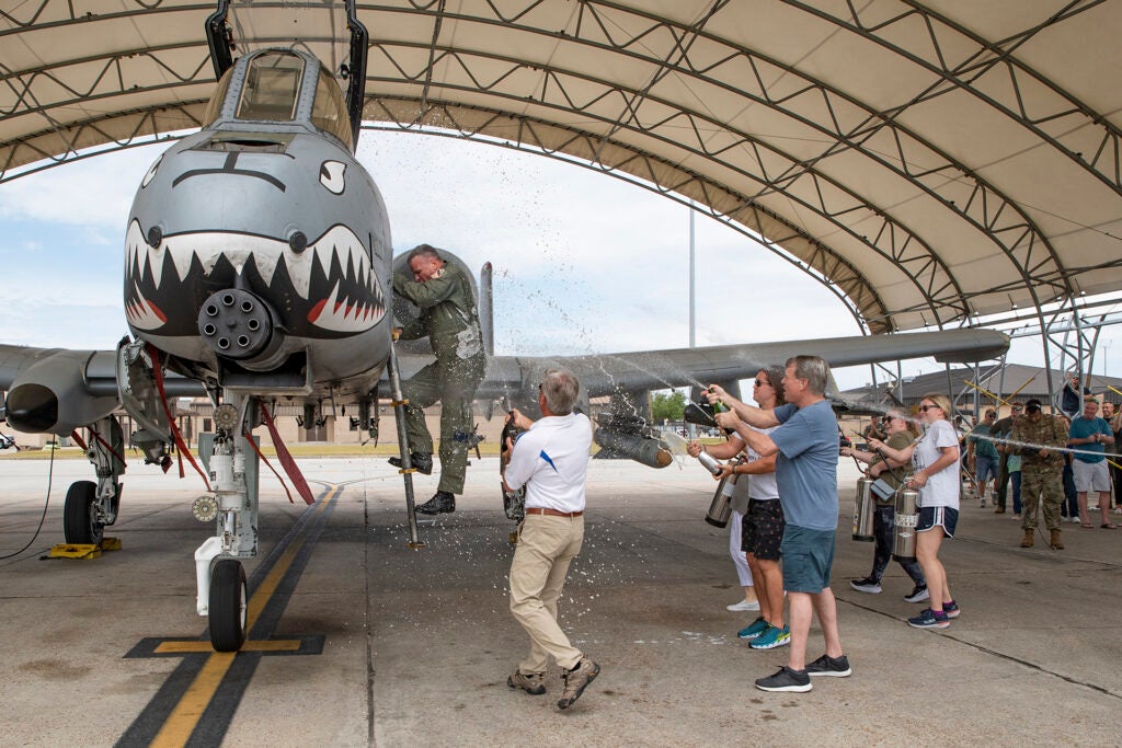 U.S. Air Force Lt. Col. Rob Sweet, 76th Fighter Squadron pilot, climbs out of an A-10C Thunderbolt II after his final flight Jun 5, 2021, at Moody Air Force Base, Georgia. The final flight, commonly known as a "fini flight," is the last flight an aviator takes at a duty station. (U.S. Air Force photo by Andrea Jenkins)
