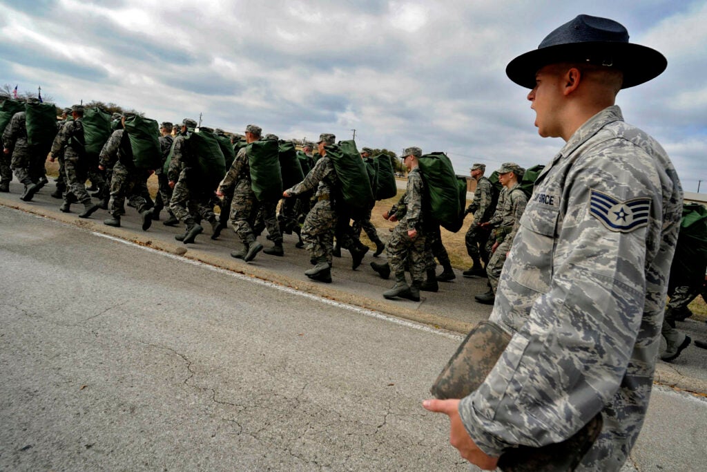 Staff Sergeant Robert George, Military Training Instructor, Flight 310, 324 Training Squadron, marches his flight down Truemper St. after the new basic trainees got their issued uniforms and Air Force gear.