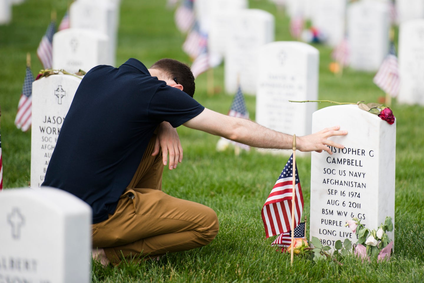 Austin Williams visits the gravesite of U.S. Navy Petty Officer 1st Class Christopher C. Campbell in Section 60 of Arlington National Cemetery on Memorial Day, May 30, 2016. Campbell was one of 30 Americans killed when a CH-47 Chinook helicopter, with the call sign Extortion 17, crashed in Afghanistan. 