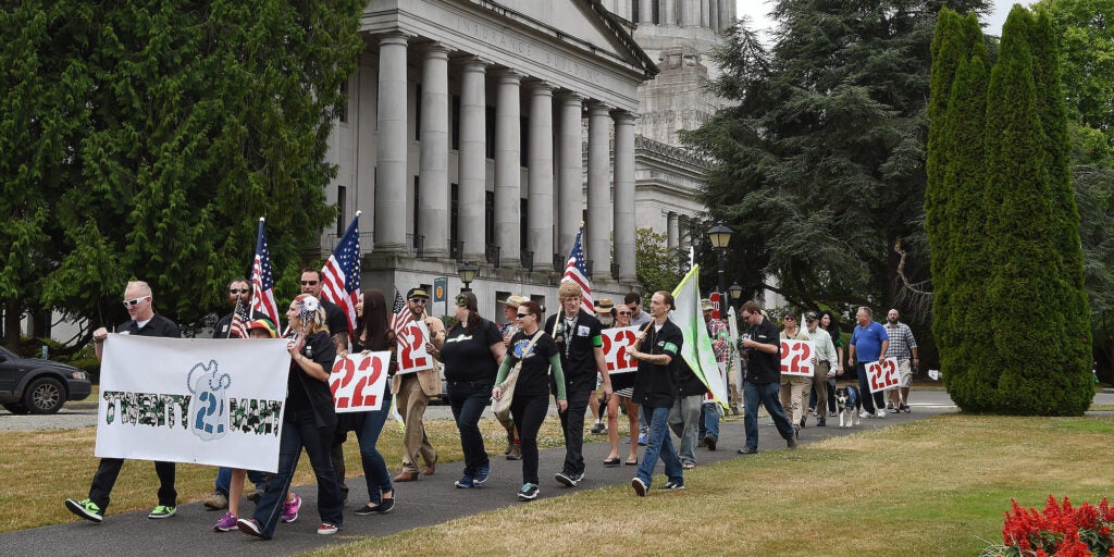 A group of veterans and supporters march from the steps of the Legislative Building for a Twenty22Many rally, Wednesday, July 22, 2015, in Olympia,Wash. The group marched to promote reducing suicide rates among military veterans with help from medical marijuana. (Steve Bloom/The Olympian via AP)