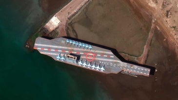 Iran sank a replica US aircraft carrier, then left it in the Strait of Hormuz where it's likely to disrupt vital shipping lanes