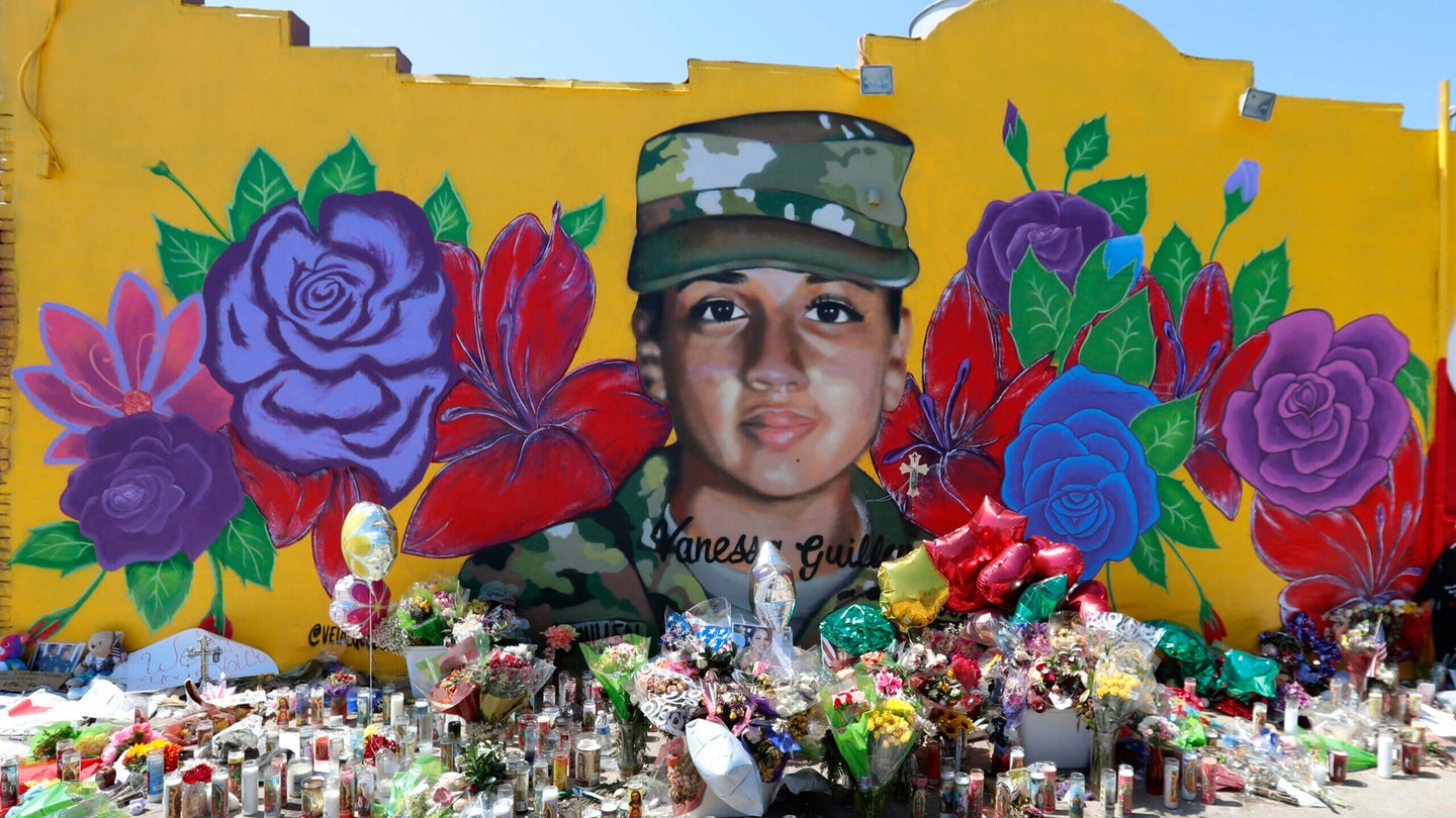 Offerings sit in front of a mural of slain Army Spc. Vanessa Guillen painted on a wall in the south side of Fort Worth, Texas, Saturday, July 11, 2020. (AP Photo/LM Otero)