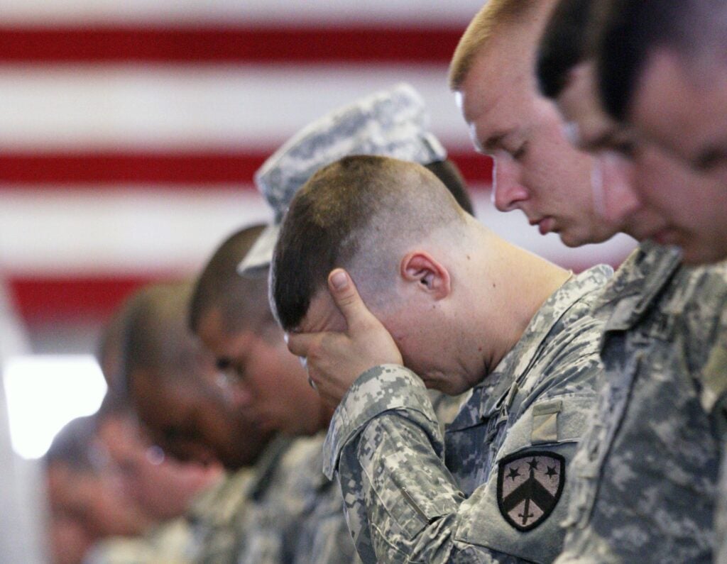 A soldier puts his hand over his face as a chaplain says a prayer while standing in formation during a deployment ceremony at the Tennessee National Guard Headquarters Wednesday, April 25, 2012 in Chattanooga, Tenn.  About 200 area National Guard troops are leaving Thursday morning to deploy to Kuwait for a one year mission. (AP Photo/Chattanooga Times Free Press, Doug Strickland) MANDATORY CREDIT: DOUG STRICKLAND/CHATTANOOGA TIMES FREE PRESS; NOOGA.COM OUT