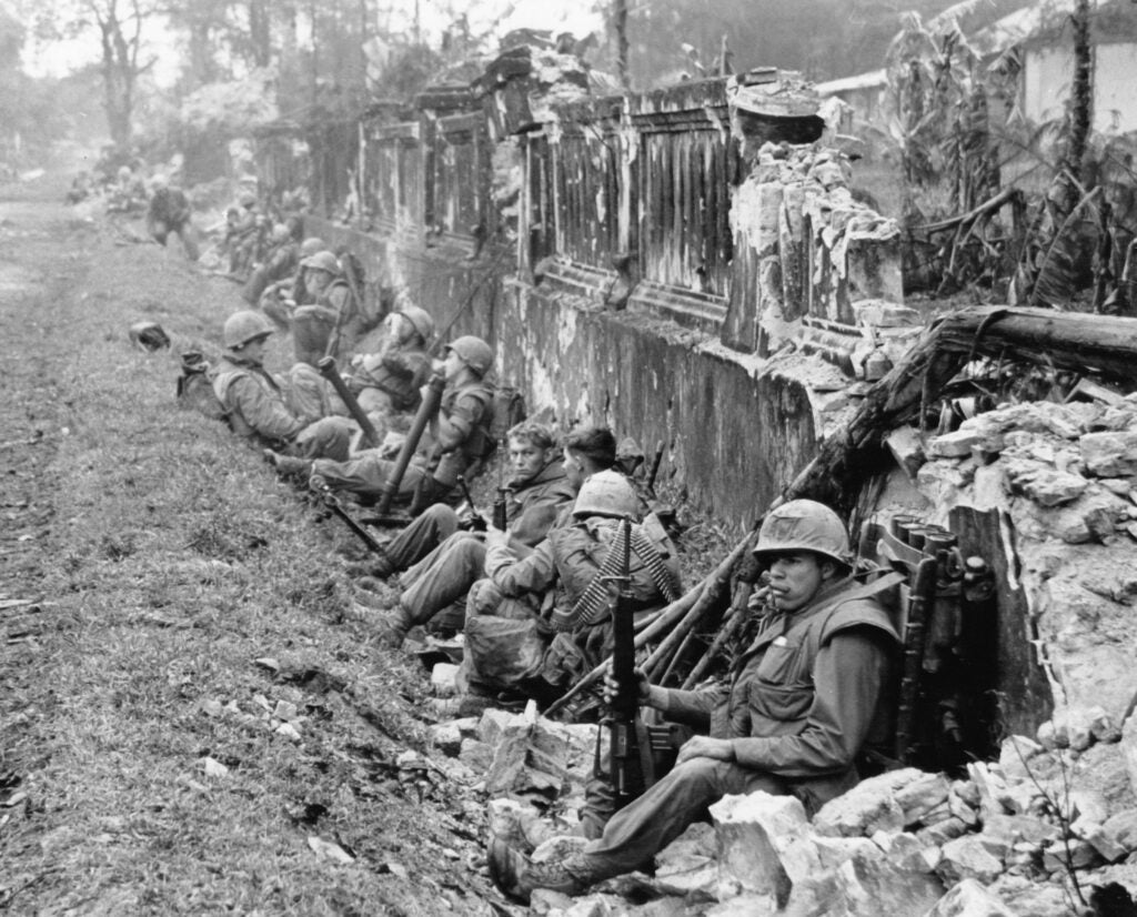 A unit of the 1st Battalion, 5th Regiment U.S. Marines, rests alongside a battered wall of Hue's imperial palace after a battle for the Citadel in February 1968, during the Tet Offensive. The Marines reported heavy casualties in street fighting in the ancient capital city of Vietnam. (AP Photo)