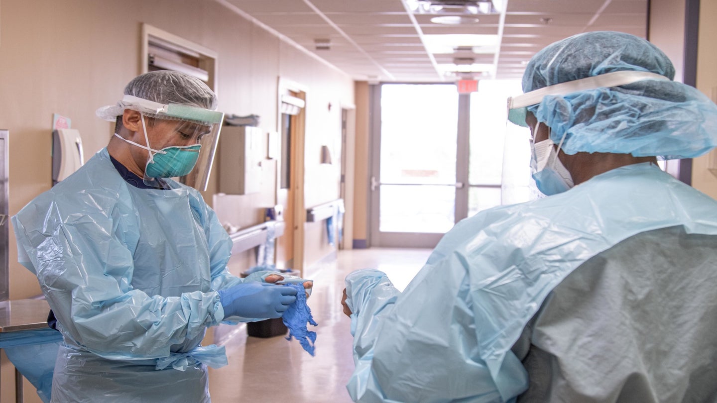 U.S. Air Force Capt. Ramil Labiran, a registered nurse with Brooke Army Medical Center, Fort Sam Houston, Texas, dons personal protective equipment while discussing patient care with Staff Sgt. LaShauna Brown, a medical technician and noncommissioned officer in charge of the pediatric intensive care unit of Walter Reed National Military Medical Center in Bethesda, Md., before entering a patient room at an intensive care unit within University Medical Center in El Paso, Texas, Nov. 16, 2020. These airmen, with 37 years of collective military experience between them, are ready for whatever COVID-19 may bring. U.S. Northern Command, through U.S. Army North, remains committed to providing flexible Department of Defense support to the Federal Emergency Management Agency in support of the whole-of-America COVID-19 response. (U.S. Army photo by Sgt. Samantha Hall)