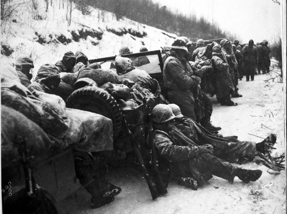 Marines of the 5th and 7th regiments who hurled back a surprise onslaught by three Chinese communist divisions wait to withdraw from the Chosin Reservoir area circa December 1950. National Archives photo