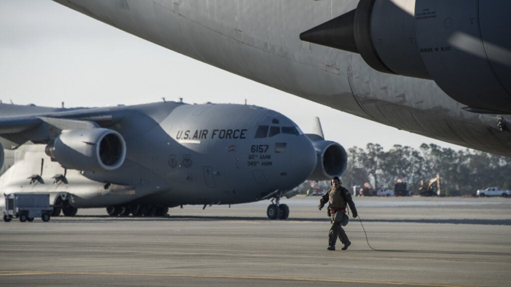 A U.S. Airman assigned to the 60th Air Mobility Wing surveys a C-5 M Super Galaxy prior to launch, May 18, 2018 at Travis Air Force Base, Calif. (Heide Couch/U.S. Air Force).