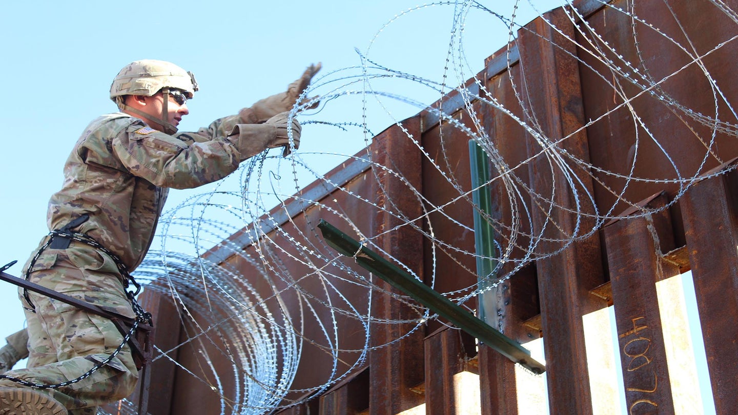 Pfc. Nicholas Young, 87th Sapper Company, places concertina wire on the Arizona-Mexico border wall, Nov. 10, 2018. Soldiers will provide a range of support including planning assistance, engineering support, equipment and resources to assist the Department of Homeland Security along the southwest border. (Army photo by 2nd Lt. Corey Maisch)