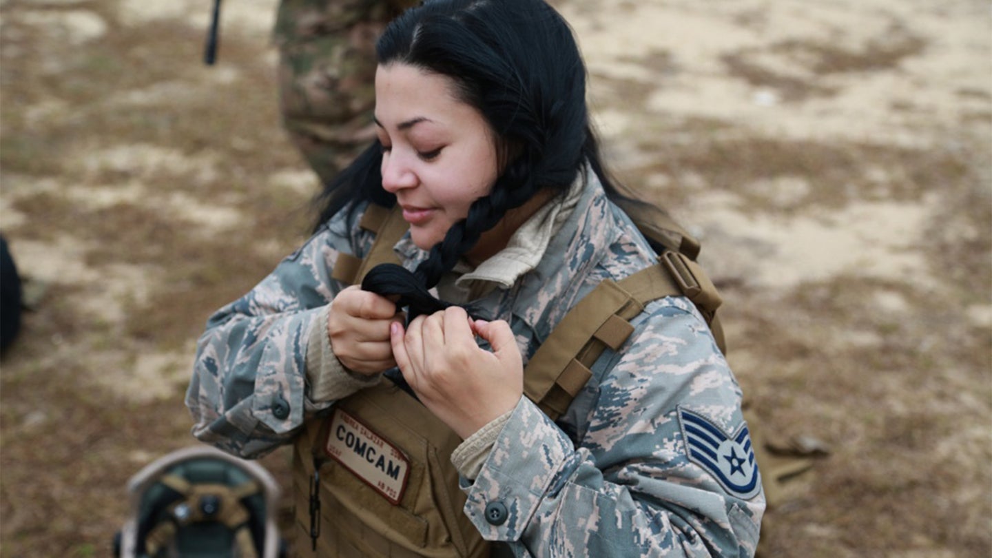 U.S. Air Force Staff Sgt. Andrea Salazar, 1st Combat Camera Squadron combat photojournalist from Joint Base Charleston, S.C., braids hair to prepare for close quarters battle training during exercise Scorpion Lens 2016, March 5, 2016, at Fort Jackson, S.C. (Air Force photo / Sgt. Sha'Quille Stokes)