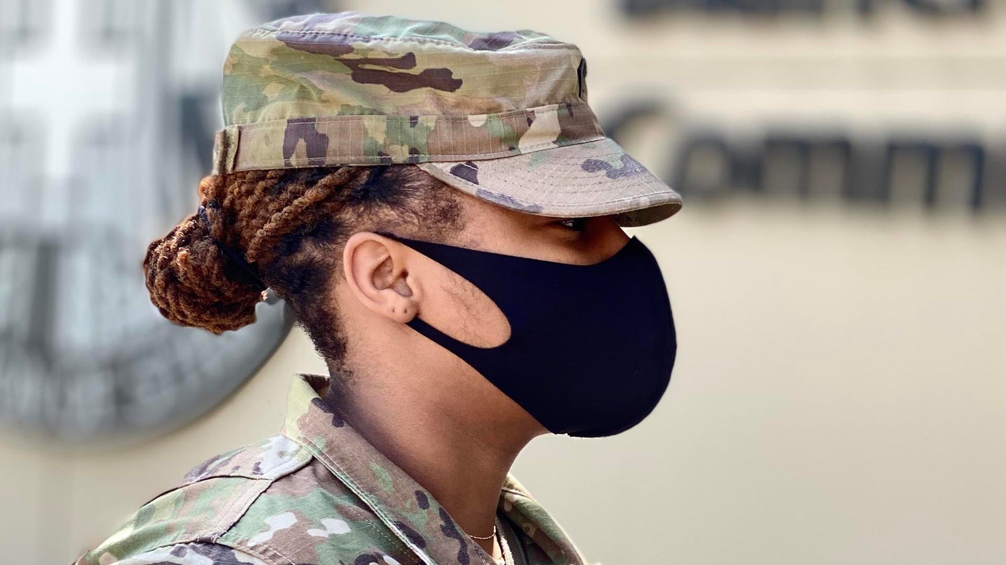 Spc. Sierra Brown wears a cloth face covering as she enters Blanchfield Army Community Hospital on Fort Campbell, Kentucky. Department of Defense policy requires all individuals on DoD property, installations, and facilities to wear cloth face coverings when they cannot maintain six feet of social distance in public areas or work centers. Beneficiaries should bring a cloth face covering when visiting the hospital, pharmacies or outlying clinics. Some exceptions may apply to include young children and medical necessity. U.S. Army photo by Maria Yager.