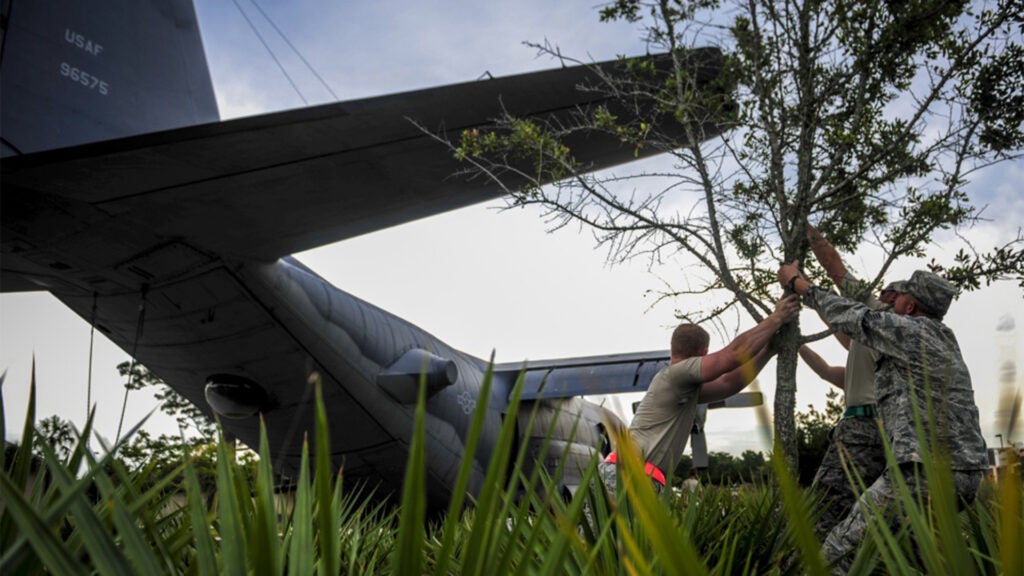 Airmen with the 1st Special Operations Aircraft Maintenance Squadron move a tree to avoid contact with the tail of an AC-130H Spectre on Hurlburt Field, Fla., Aug. 15, 2015. More than 40 personnel with eight base organizations were on site during the tow process. The AC-130H Spectre will be displayed at the north end of the Air Park. (Air Force photo / Senior Airman Meagan Schutter)