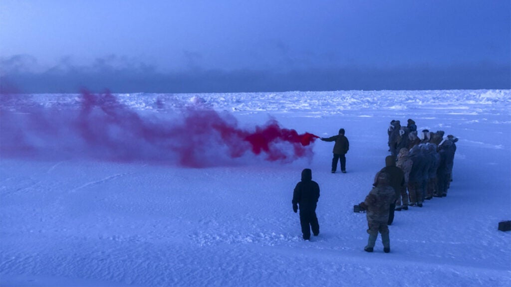 Air Force Staff Sgt. Samuel Ley, a 66th Training Squadron, Detachment 1 survival, evasion, resistance and escape (SERE) specialist, demonstrates how to use an MK-124 smoke and illumination signal on the Chukchi Sea Jan. 13, 2021. The MK-124 is a smoke and illumination flare used to signal search and rescue personnel in the event of an emergency or extraction situation. (Air Force photo / Maj. Tyler Williams)
