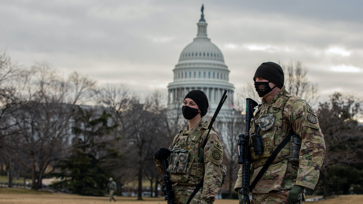 U.S. Army Pfc. Rebekah Bouman, left, and Sgt. Benjamin Stroll, both military policemen with the 46th Military Police Company, Michigan National Guard, stand watch near the U.S. Capitol in Washington, Feb. 23, 2021.