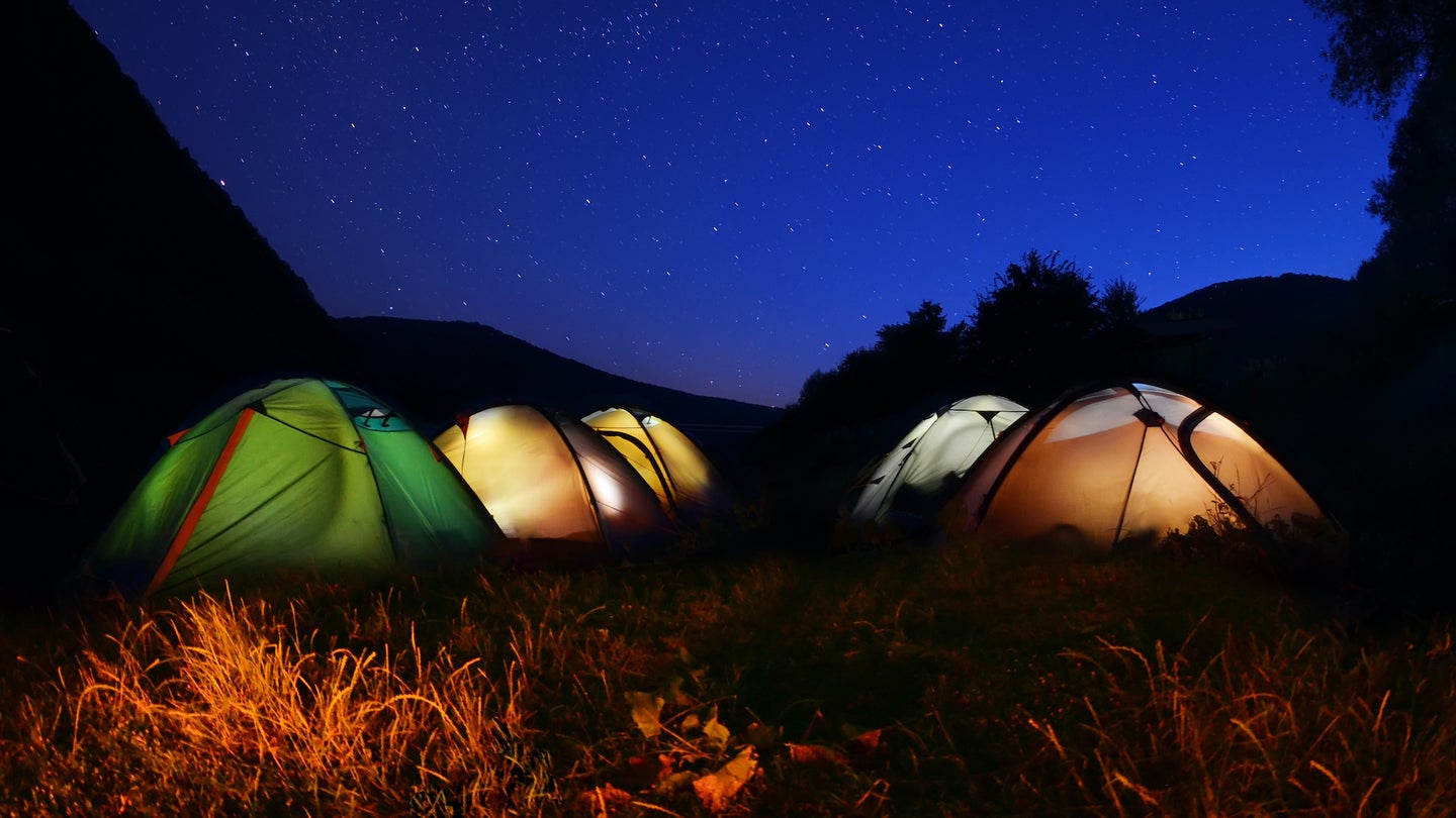 Tents glow at night   in the forest in Dnestrovskij-Kanon, Ukraine.