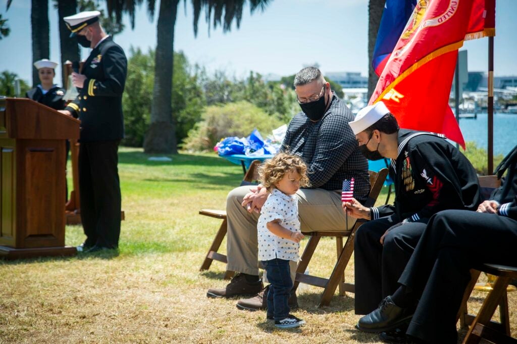 210514-N-LW757-1075SAN DIEGO (May 14, 2021) Hospital Corpsman 1st Class Luis Fonseca, a Sailor assigned to Naval Medicine Readiness and Training Unit Marine Corps Recruit Depot (MCRD) San Diego, receives a flag from his son during a retirement ceremony held at MCRD San Diego May 14. Hospital Corpsman 1st Class Luis Fonseca was the Navy’s most decorated active duty hospital corpsman, and received the Navy Cross as a hospitalman apprentice for extraordinary heroism while serving with the First Marine Expeditionary Force in support of Operation Iraqi Freedom Mar. 23, 2003. Fonseca and his wife, Hospital Corpsman 1st Class Christina Fonseca (ret.), who officially retired in Feb. 2021, retired together in a joint ceremony, and have a combined 46 years of Naval service. Navy Medicine Readiness and Training Command (NMRTC) San Diego's mission is to prepare service members to deploy in support of operational forces, deliver high quality healthcare services and shape the future of military medicine through education, training and research. NMRTC employs more than 6,000 active duty military personnel, civilians, and contractors in Southern California to provide patients with world-class care anytime, anywhere. (U.S. Navy photo by Mass Communication Specialist 3rd Class Luke Cunningham)