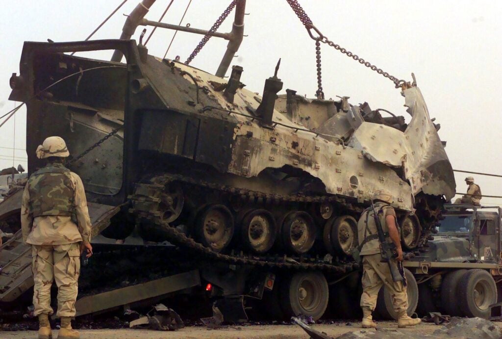 US Marine Corps (USMC) Marines assigned to Combat Services Support Battalion 18 (CSSB-18) work to retrieve a destroyed USMC Amphibious Assault Vehicle, (AAV7A1), during Operation IRAQI FREEDOM.