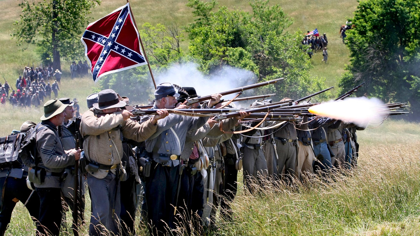 In this Saturday, June 9, 2012, photo, Civil War reenactors portray Confederate troops opening fire on Union troops during a reenactment of the Battle of Cross Keys on its 150th anniversary at the Cedar Creek Battlefield south of Middletown, Va. (AP Photo/The Winchester Star, Ginger Perry)