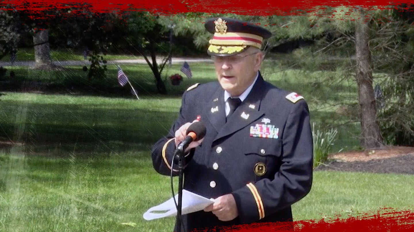 Army veteran, Lt. Col. Barnard Kemter, tests his microphone during a speech at a Memorial Day ceremony in Ohio. 