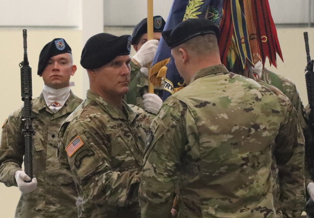 Command Sgt. Maj. Stephen Siglock, incoming 2-1 Infantry Battalion command sergeant major recieves the battalion guidon from his new commander, Lt. Col. Blake Witherell, accepting responsibility as senior enlisted advisor at Joint Base Lewis McChord on Nov 25 2019.