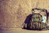 Hiking backpack camping and mountain exploring tourist equipment outdoor on grunge wall. Adventure, summer, tourism active lifestyle