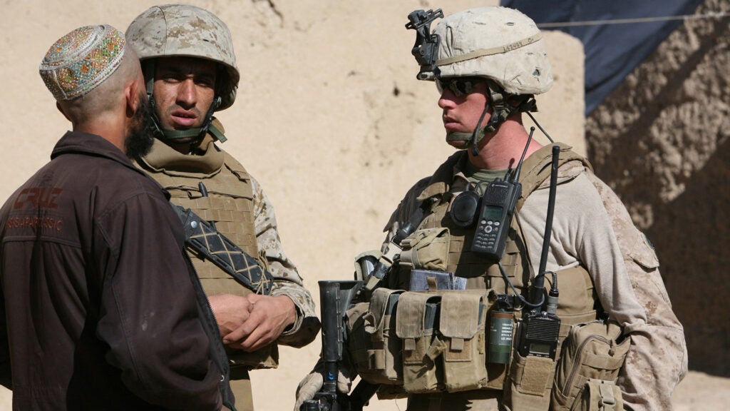 With the help of an interpreter Marine Cpl. Devon Sanderfield speaks with a villager in the town of Changwalok, Afghanistan, Dec. 6, 2009. (U.S. Marine Corps photo by Cpl. Zachary Nola.)