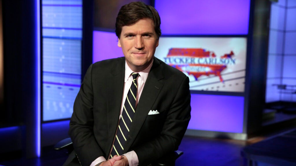 FILE - In this Thursday, March 2, 2017 file photo, Tucker Carlson, host of "Tucker Carlson Tonight," poses for a photo in a Fox News Channel studio in New York. The Anti-Defamation League has called for Fox News to fire prime-time opinion host Tucker Carlson because he defended a white-supremacist theory that says whites are being “replaced” by people of color. In a letter to Fox News CEO Suzanne Scott on Friday, April 9, 2021the head of the ADL, Jonathan Greenblatt, said Carlson's “rhetoric was not just a dog whistle to racists — it was a bullhorn.”  (AP Photo/Richard Drew, File)