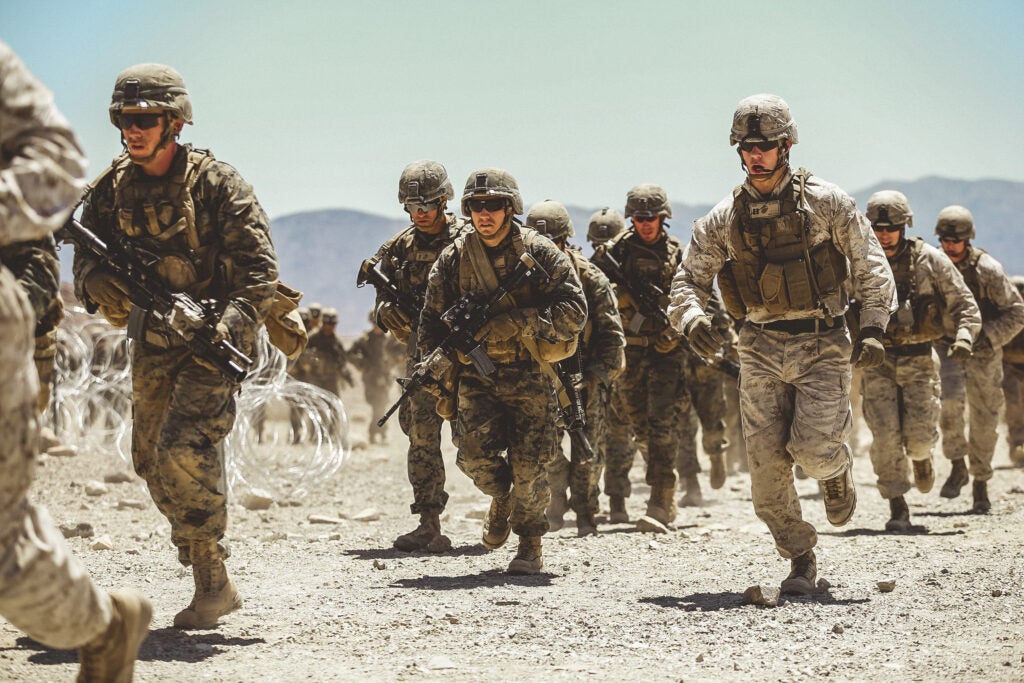 Marines in the Infantry Officer Course run to to their first objective during a live fire training exercise at Range 410A aboard the Marine Corps Air Ground Combat Center, Twentynine Palms, Calif., June 9, 2018. The Purpose of IOC is to train and educate newly selected infantry and ground intelligence officers in leadership, infantry skills, character required to serve as infantry platoon commanders in the operating forces. (U.S. Marine Corps photo by Lance Cpl. William Chockey)