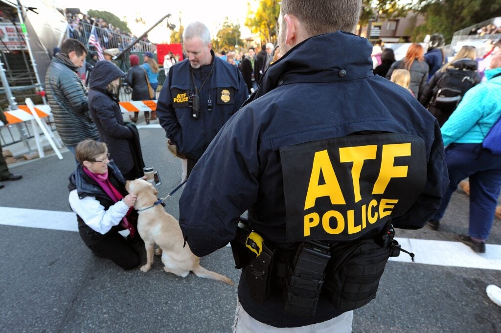 Bureau of Alcohol, Tobacco, Firearms and Explosives agents patrol the route of the 127th Rose Parade as explosives detecting canine Abby gets petted by a parade spectator in Pasadena, Calif., Friday, Jan. 1, 2016.  (AP Photo/Michael Owen Baker)
