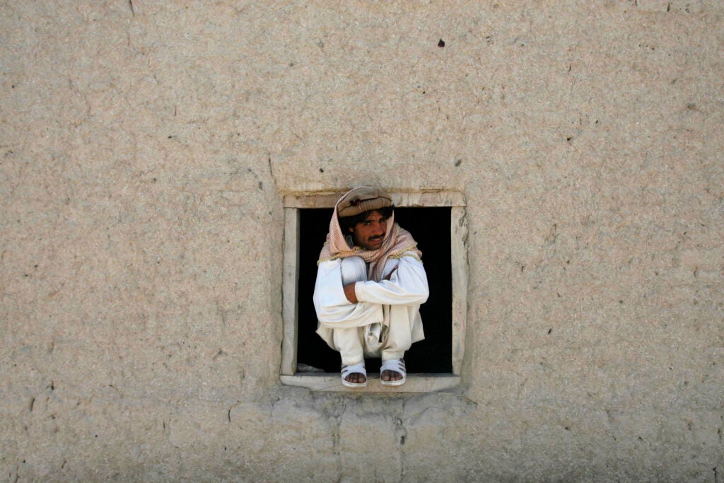 Afghan man looks on as U.S. soldiers of the 101st Airborne Division patrol in Khost province, Afghanistan, Thursday, April 17, 2008. U.S. troop levels in Afghanistan now top 32,000, the highest number of American forces in the country since the 2001 U.S.-led invasion that toppled the Taliban. (AP Photo/Rafiq Maqbool)