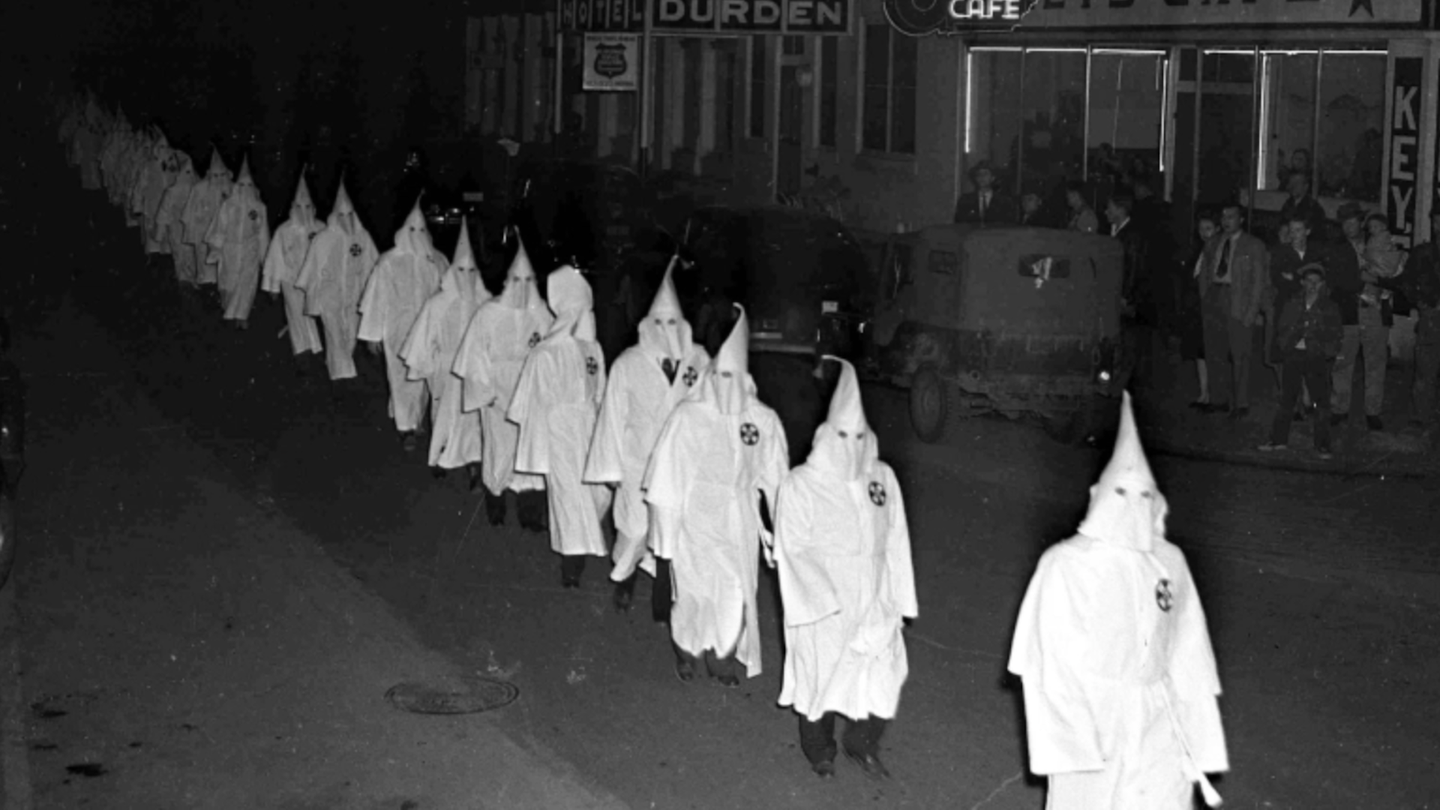 Ku Klux Klansmen in full regalia, march around the town square, Swainsboro, Georgia, USA, Feb. 4th, 1948, prior to burning a cross outside the Emanuel County Courthouse. 