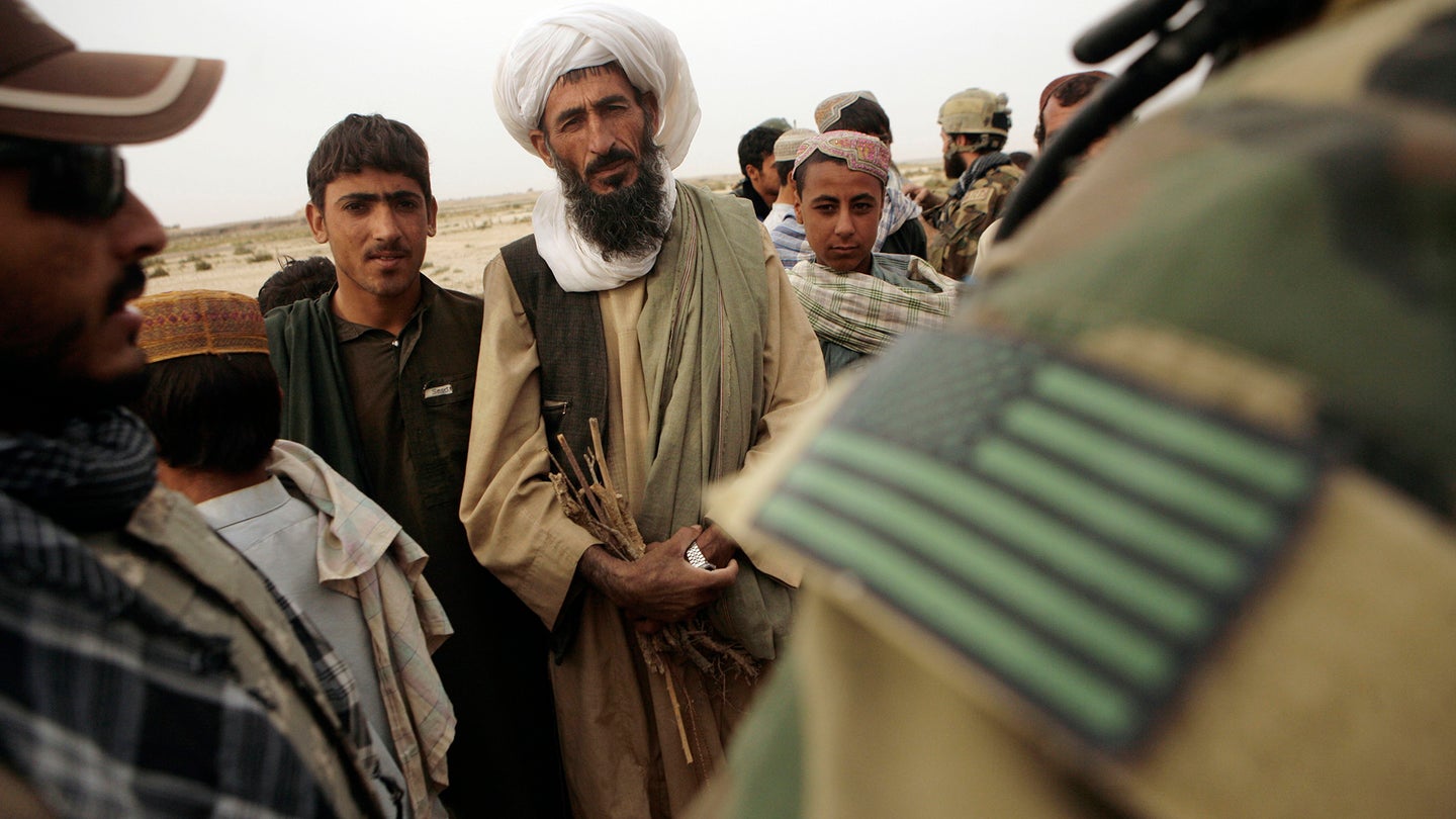 FILE PHOTO: An Afghan man speaks to a member of U.S. special operations forces with the help of an interpreter in Afghanistan's Farah province, Sunday, Nov. 1, 2009. (AP Photo/Maya Alleruzzo)