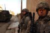 U.S. Army Spc. Robb Mellard and Staff Sgt. Andrew Steen watch a corner for enemy threats while on a patrol, Dec. 28, 2007, Baghdad, Iraq. The Soldiers are from Nemesis Troop, 1st Platoon, 2nd Stryker Cavalry Regiment.