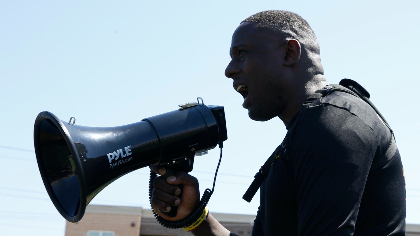 Chief Information Systems Technician Greg Charles, from Brooklyn, New York, assigned to USS Gerald R Ford's (CVN 78) combat systems department, yells into the megaphone during a mentorship sports day that focused on team building, cooperation and leadership on May. 16, 2019.