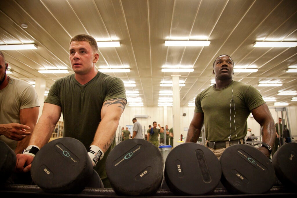 U.S. Marine Corps Lance Cpls. Adrian Kochanowicz, left, and Matiyes Kinker, both assaultmen, from Brooklyn, N.Y. and Cleveland, Ohio, respectively, and assigned to 1st Platoon, Fox Company, 2nd Battalion, 8th Marine Regiment, rest a moment while lifting weights in the fitness center on Camp Leatherneck, Helmand province, Afghanistan, June 28, 2013. Kochanowicz and Kinker work out to maintain their physical fitness and operational readiness. (U.S. Marine Corps photo by Cpl. Alejandro Pena/Released)