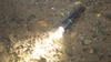 The author threw the lit flashlight at rocks and into a river repeatedly. The Olight Warrior Mini 2 didn’t even flicker.