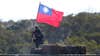 A soldier holds a Taiwan national flag during a military exercise in Hsinchu County, northern Taiwan, Tuesday, Jan. 19, 2021. Taiwanese troops using tanks, mortars and small arms staged a drill Tuesday aimed at repelling an attack from China, which has increased its threats to reclaim the island and its own displays of military might. (AP Photo/Chiang Ying-ying)
