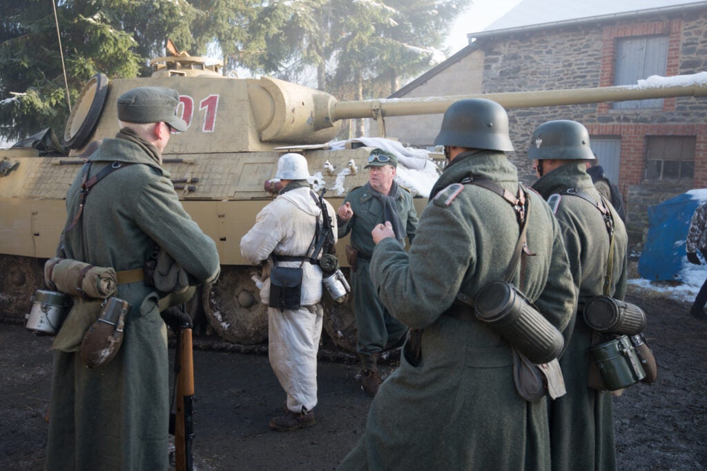 Re-enactors with the AA7 group in Poland gather around their Panzer V Panther tank replica based on a Russian T55, before the Battle of the Bulge's combat reenactment for the 70th anniversary commemorations in Bastogne, Belgium, Dec. 14, 2014. (U.S. Army photo by Visual Information Specialist Pierre-Etienne Courtejoie/Released)