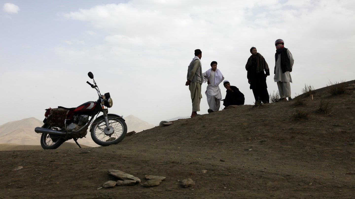 A group of Afghans socialize next to one of their motorcycles near the village of Syahchob, Sayed-Abad District, Wardak province, Afghanistan, Aug. 1, 2010.