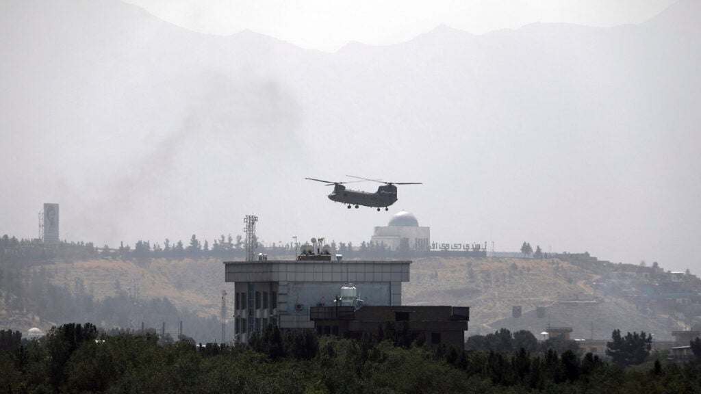 A U.S. Chinook helicopter flies over the U.S. Embassy in Kabul, Afghanistan, Sunday, Aug. 15, 2021. Helicopters are landing at the U.S. Embassy in Kabul as diplomatic vehicles leave the compound amid the Taliban advanced on the Afghan capital. (AP Photo/Rahmat Gul)