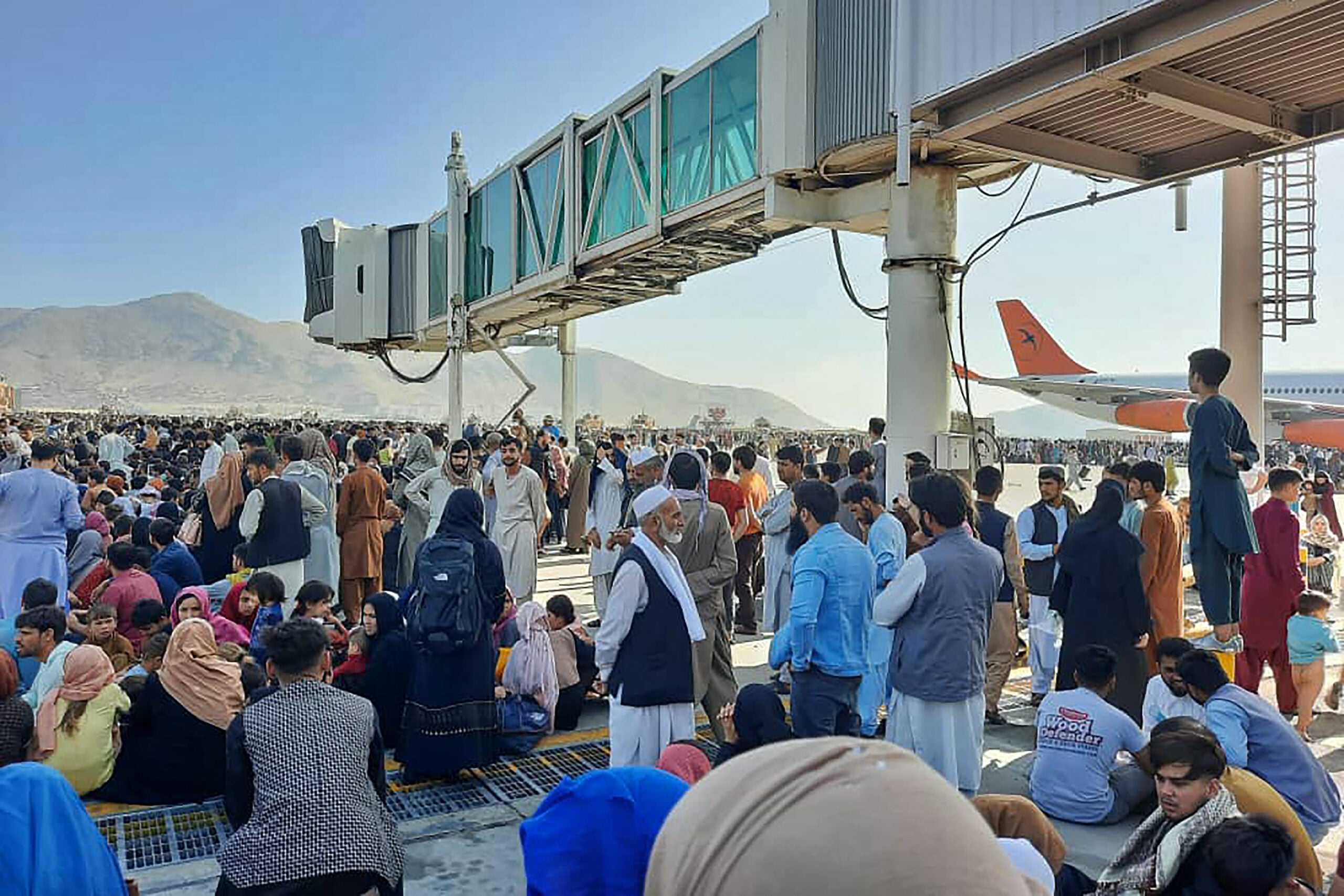 TOPSHOT - Afghans crowd at the tarmac of the Kabul airport on August 16, 2021, to flee the country as the Taliban were in control of Afghanistan after President Ashraf Ghani fled the country and conceded the insurgents had won the 20-year war. (Photo by - / AFP) (Photo by -/AFP via Getty Images)