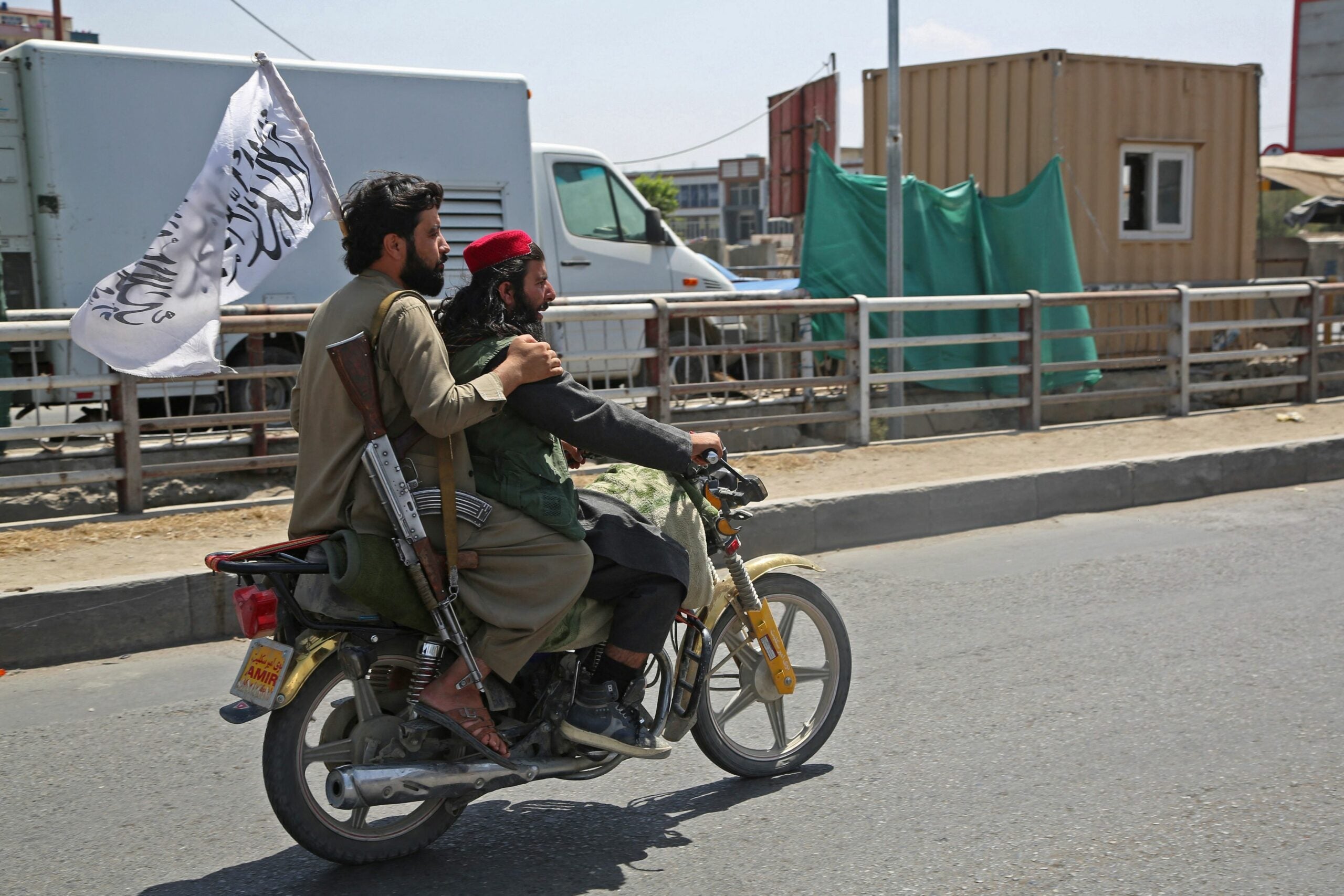 Taliban fighters ride a motorbike along the street in Kabul on August 16, 2021, after a stunningly swift end to Afghanistan's 20-year war, as thousands of people mobbed the city's airport trying to flee the group's feared hardline brand of Islamist rule. (Photo by - / AFP) / The erroneous mention[s] appearing in the metadata of this photo by Zakeria HASHIMI has been modified in AFP systems in the following manner: [-] instead of [Zakeria Hashimi]. Please immediately remove the erroneous mention[s] from all your online services and delete it (them) from your servers. If you have been authorized by AFP to distribute it (them) to third parties, please ensure that the same actions are carried out by them. Failure to promptly comply with these instructions will entail liability on your part for any continued or post notification usage. Therefore we thank you very much for all your attention and prompt action. We are sorry for the inconvenience this notification may cause and remain at your disposal for any further information you may require. (Photo by -/AFP via Getty Images)