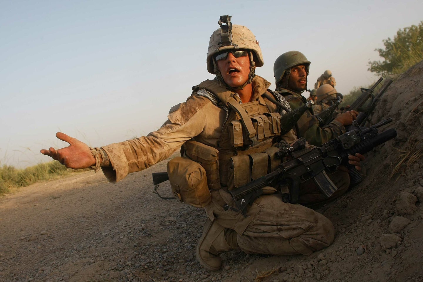 MIAN POSHTEH, AFGHANISTAN- JULY 17:  U.S. Marines with the 2nd Marine Expeditionary Brigade, RCT 2nd Battalion 8th Marines Echo Co. and an Afghan soldier take cover after taking enemy fire near where an IED was detonated on July 17, 2009 in Mian Poshteh, Afghanistan. The Marines are part of Operation Khanjari which was launched to take areas in the Southern Helmand Province that Taliban fighters are using as a resupply route and to help the local Afghan population prepare for the upcoming presidential elections.  (Photo by Joe Raedle/Getty Images)